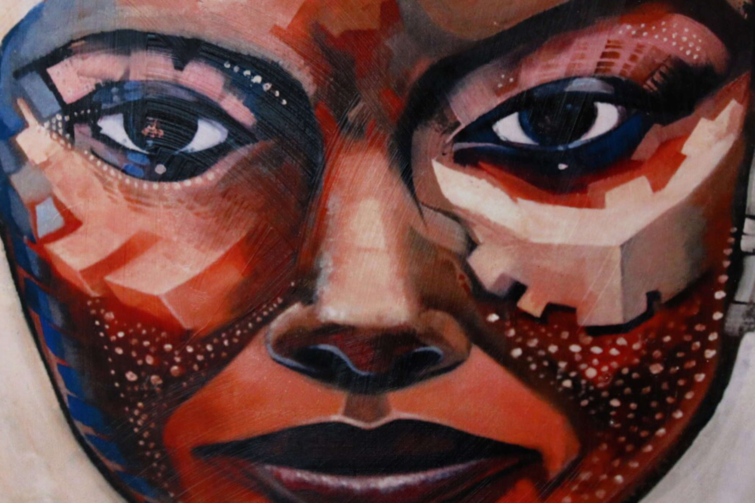 A close-up of an abstract painting depicting a human face. The face is composed of geometric shapes, varying in shades of red, brown, beige, and blue. The eyes are prominent, with expressive details, and the overall style is fragmented and textured.