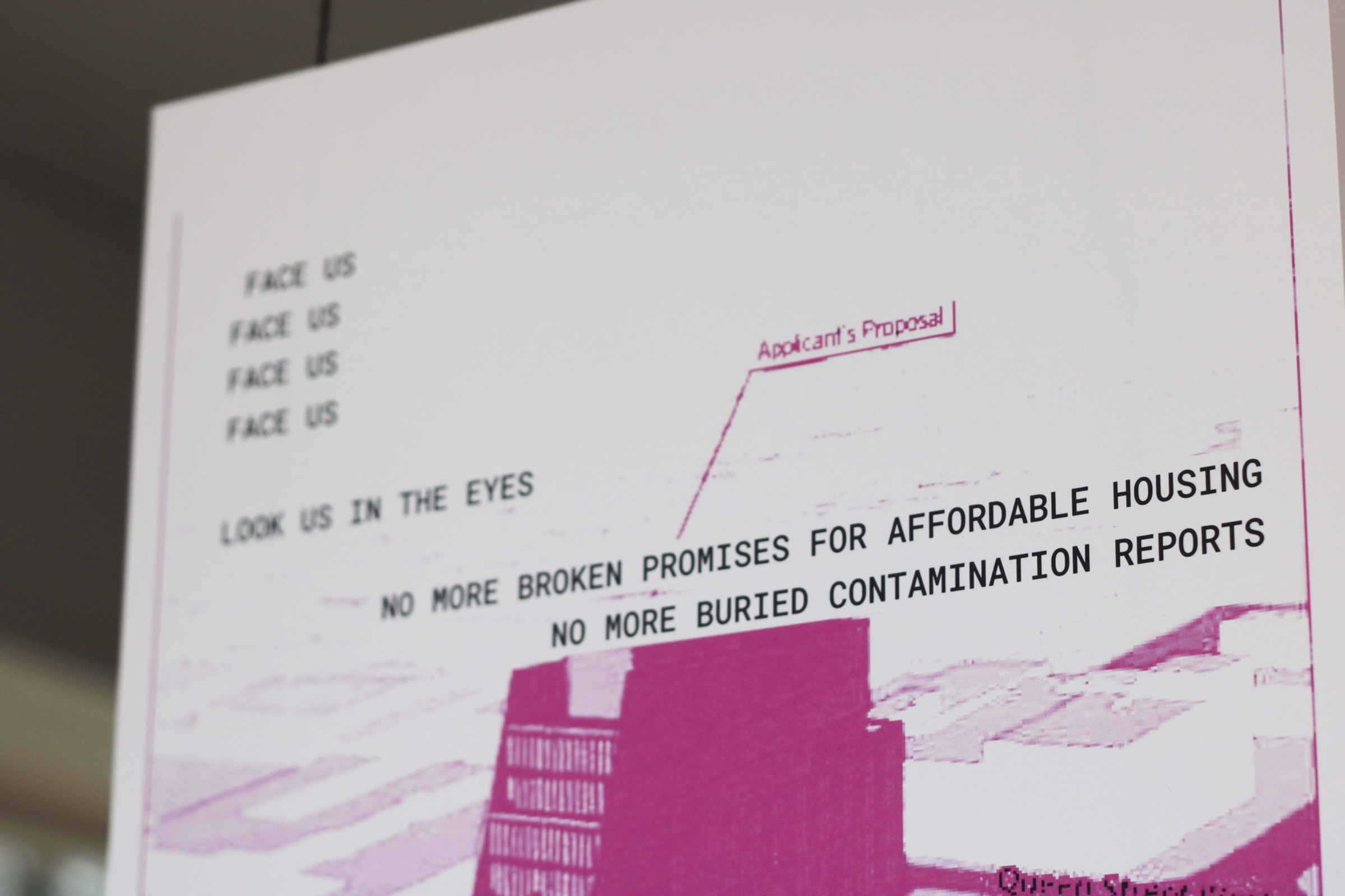 A poster shows a stylized image of a building with overlaid text reading: "FACE US, LOOK US IN THE EYES, NO MORE BROKEN PROMISES FOR AFFORDABLE HOUSING, NO MORE BURIED CONTAMINATION REPORTS." The words "Applicant's Proposal" point to the building.